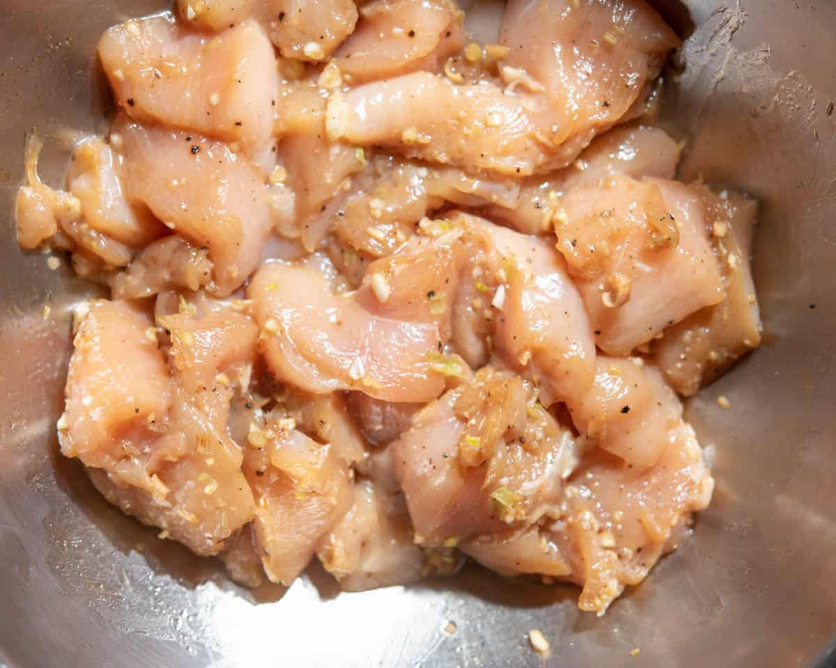 chicken marinating in bowl with garlic, lemongrass, and coconut aminos