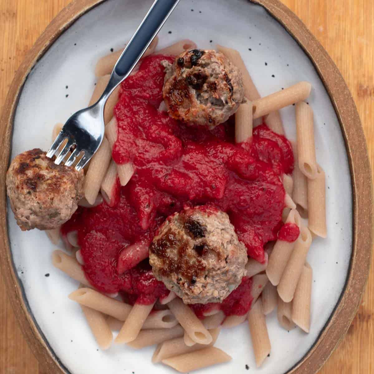 baked pork beef meatballs served with nomato sauce and cassava pasta