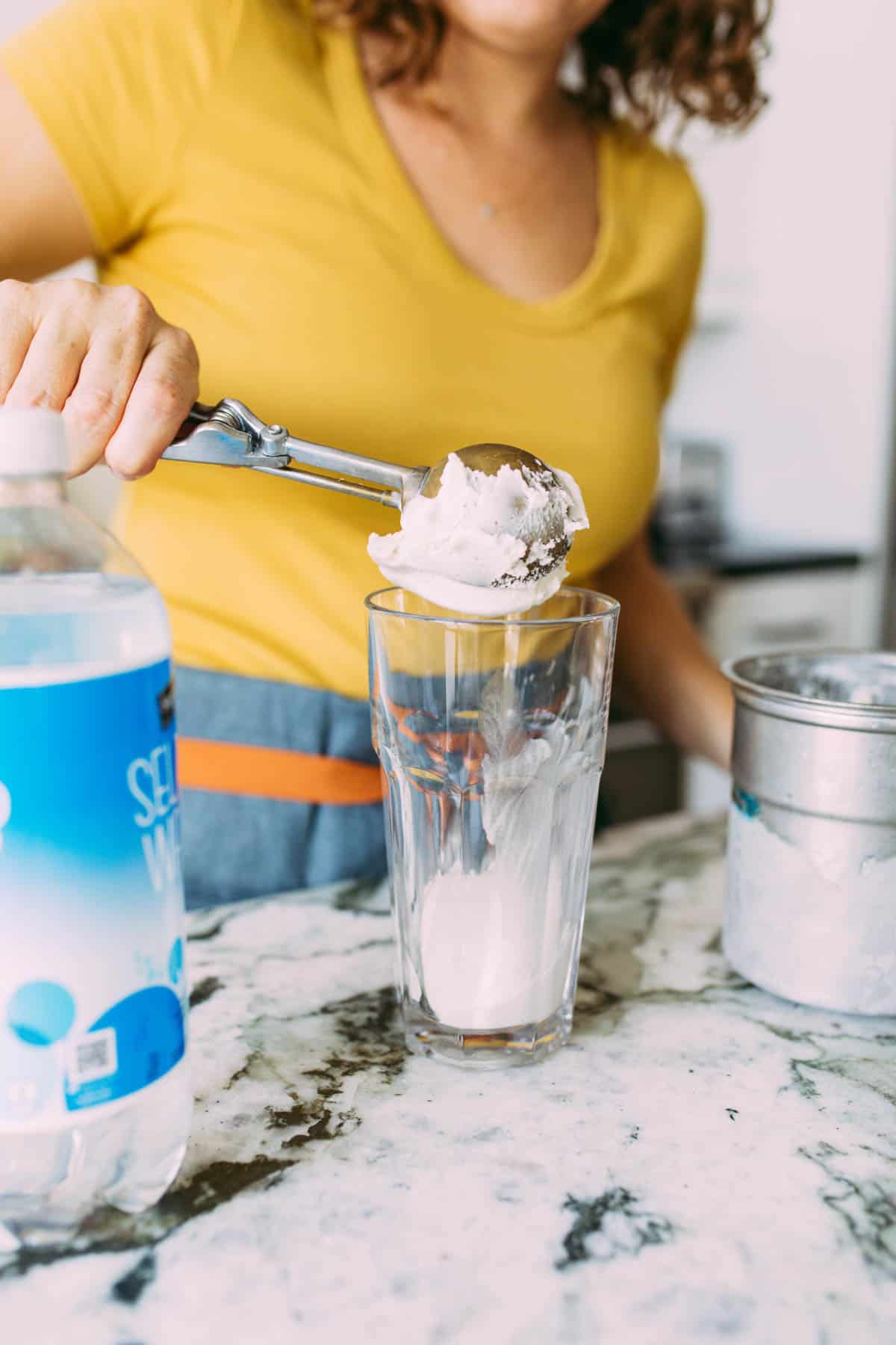 vanilla bean ice cream being scooped into glass