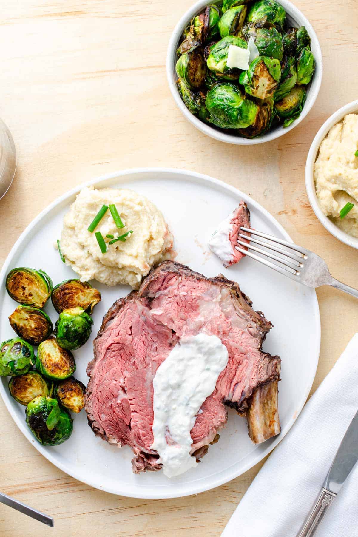 Roasted Brussels sprouts coated with balsamic vinegar and honey plated with beef and cauliflower