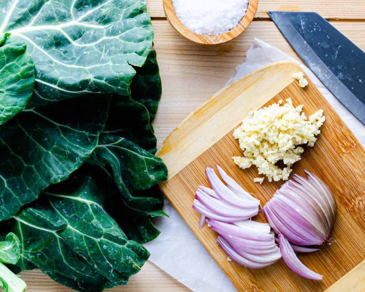 kale, shallot, garlic, sea salt, and olive oil on cutting board