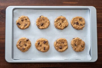 unbaked cookie dough pressed on parchment lined baking tray