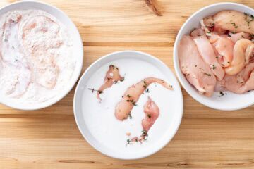 chicken tenders dipped in coconut milk in bowl