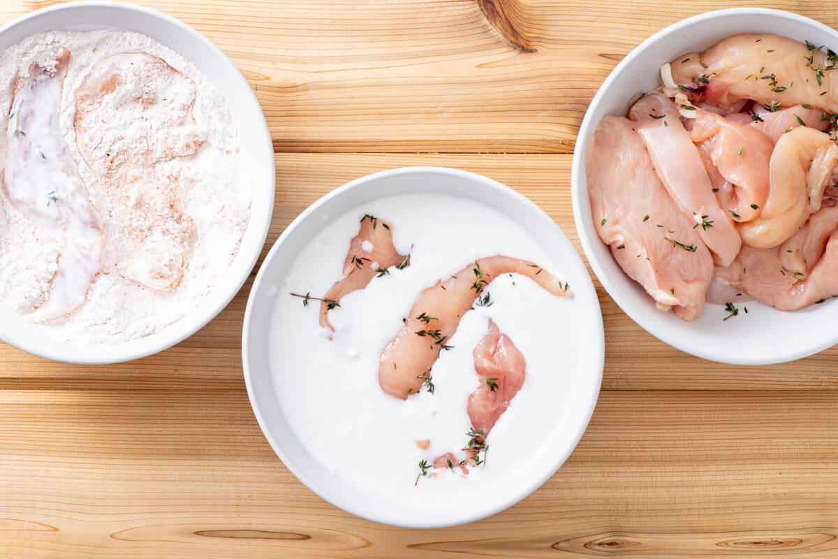 chicken tenders dipped in coconut milk in bowl