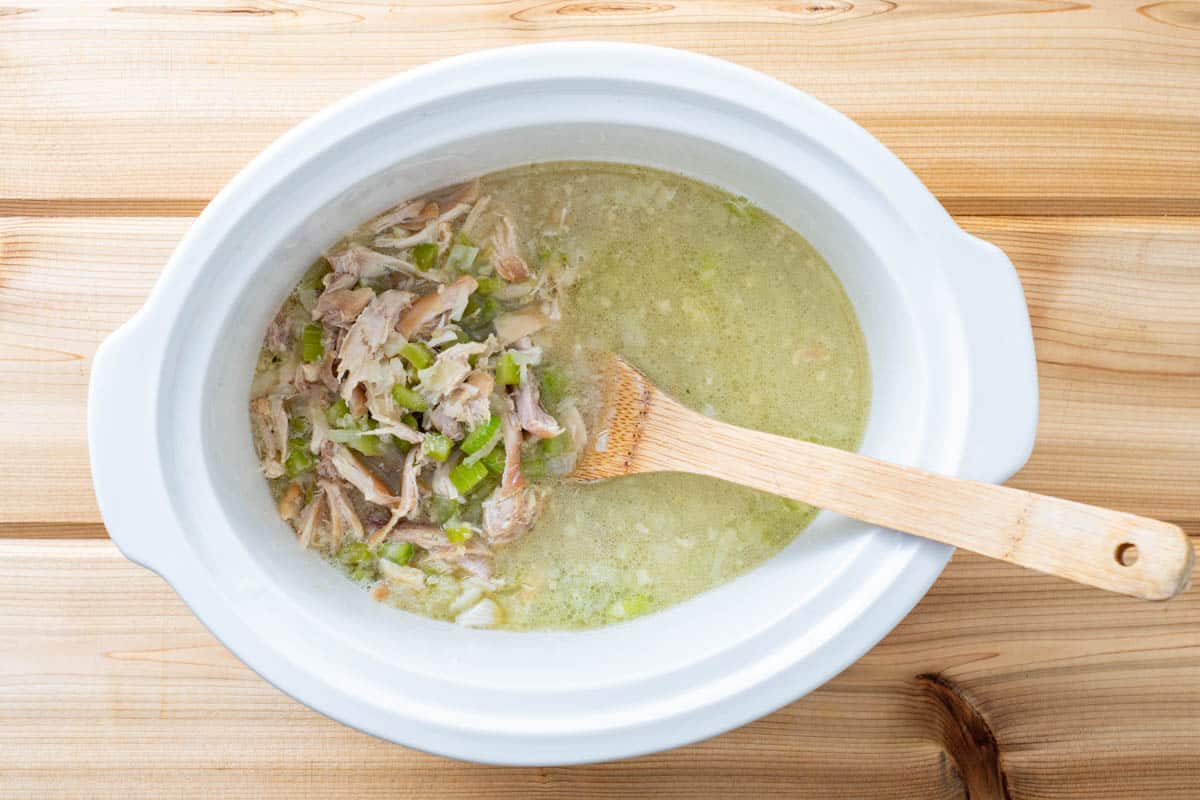 shredded chicken in pot with vegetables and water