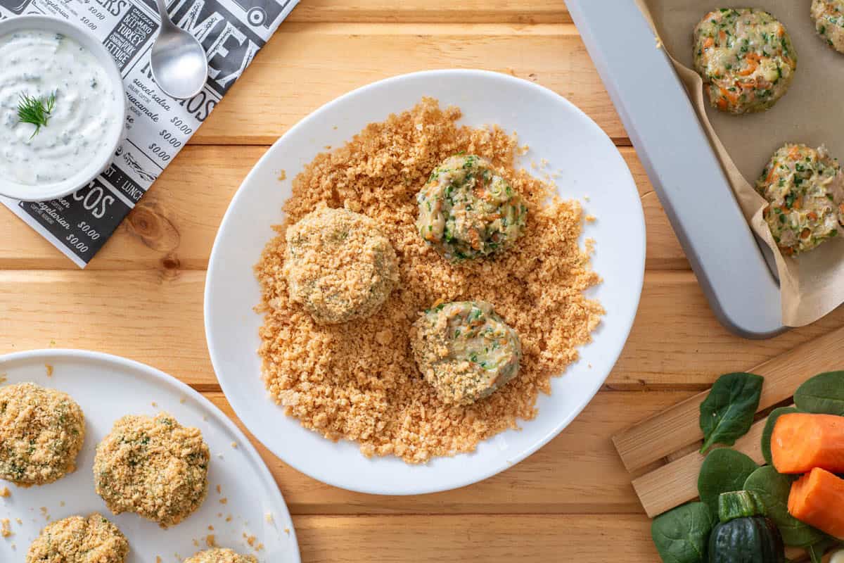 Dipping chicken nugget in paleo pork rind panko crumbs